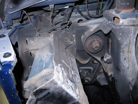 1991 Ford LTD Crown Victoria - Close-up of the front suspension and frame of a vehicle, showing various mechanical parts and wiring.