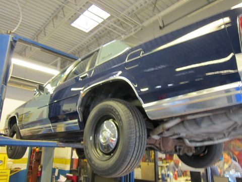 1991 Ford LTD Crown Victoria - A blue 1991 Ford Crown Victoria LTD is shown on a car lift, revealing its underside and side profile.