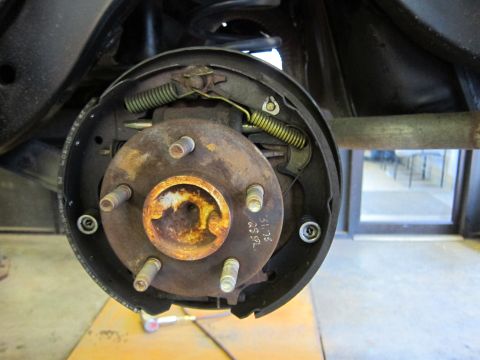 1991 Ford LTD Crown Victoria - Close-up of a rusty rear drum brake assembly, showing springs and brake shoes.