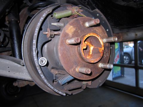1991 Ford LTD Crown Victoria - Close-up view of a rear drum brake assembly, showing the brake shoes, springs, and rusty hub.