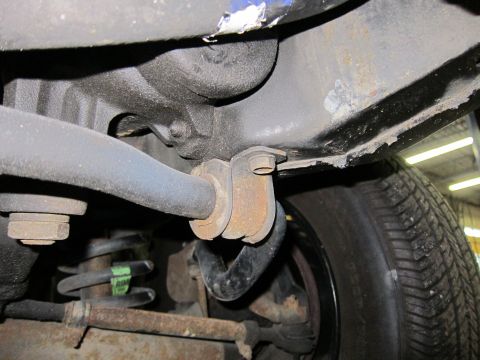 1991 Ford LTD Crown Victoria - Close-up of the undercarriage shows suspension parts including a sway bar and coil spring.