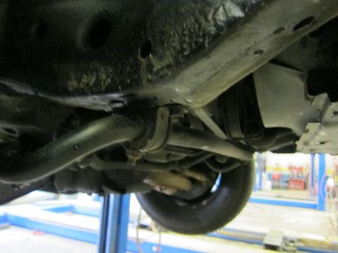 1991 Ford LTD Crown Victoria - Close-up of a car's underbody, showing suspension parts and frame structure.