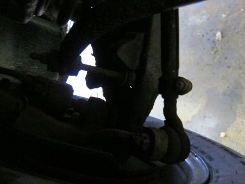 1991 Ford LTD Crown Victoria - Undercarriage view of a vehicle's suspension system and tire, showing rusty components.