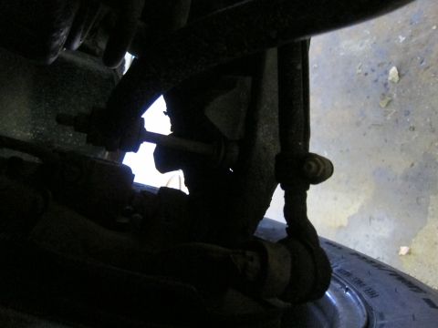 1991 Ford LTD Crown Victoria - Detail of the front suspension system and tire, showing various mechanical parts.