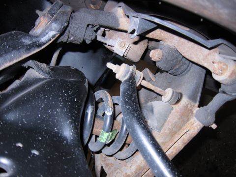 1991 Ford LTD Crown Victoria - Detail of the rear suspension system, showing the coil spring and sway bar link, with some visible green labeling on the spring.