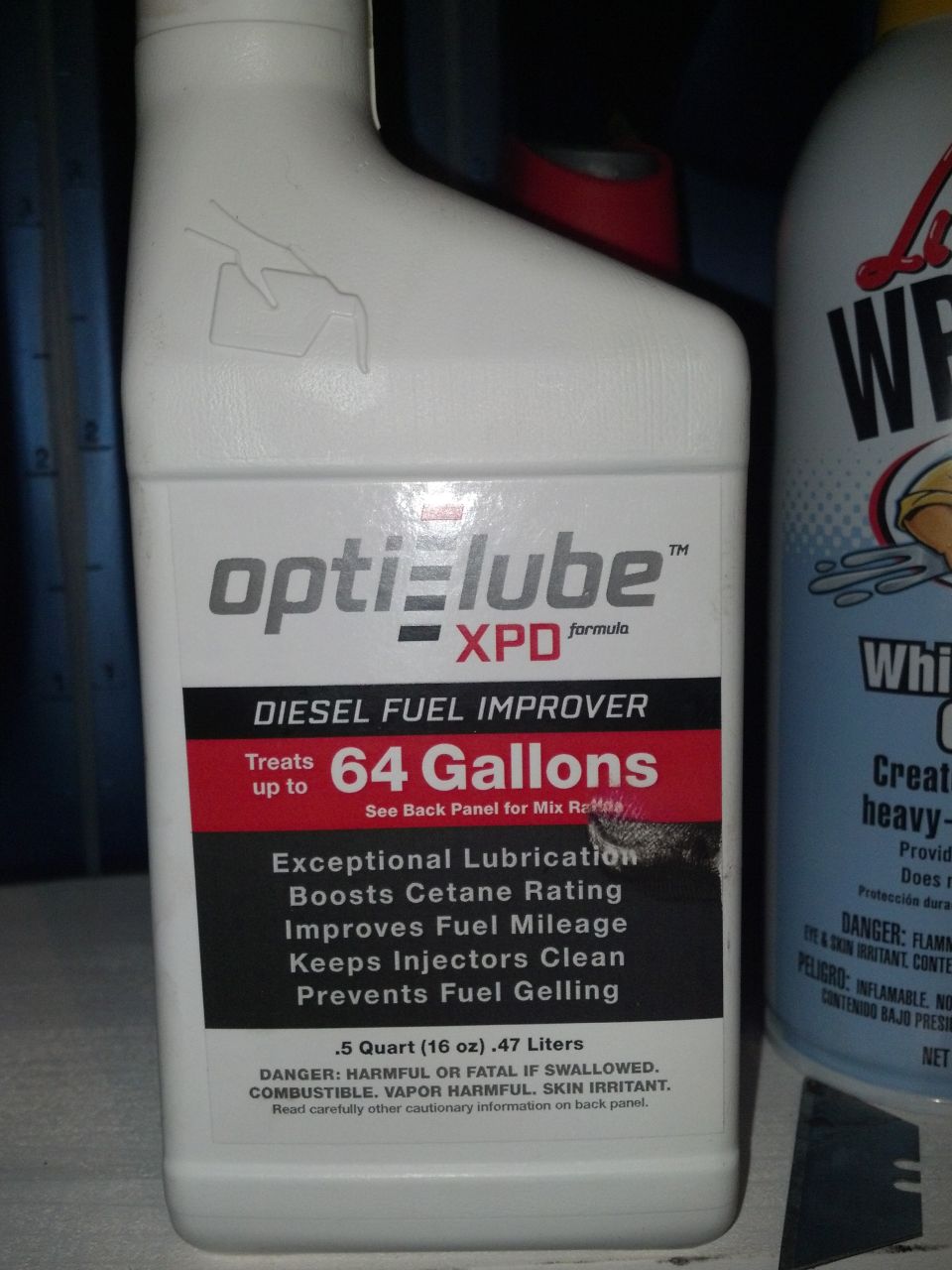 White plastic bottle of Opti-Lube XPD Diesel Fuel Improver, showing gallon capacity and benefits