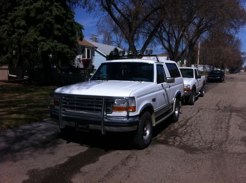 1994 Ford Bronco - A white 1992 Ford Bronco is parked on a street, with other vehicles behind it.