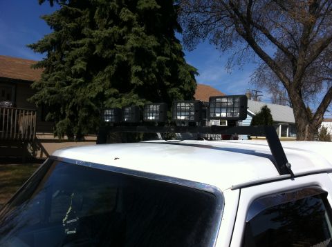 1994 Ford Bronco - Roof-mounted light bar with four square lights is attached to a white vehicle.