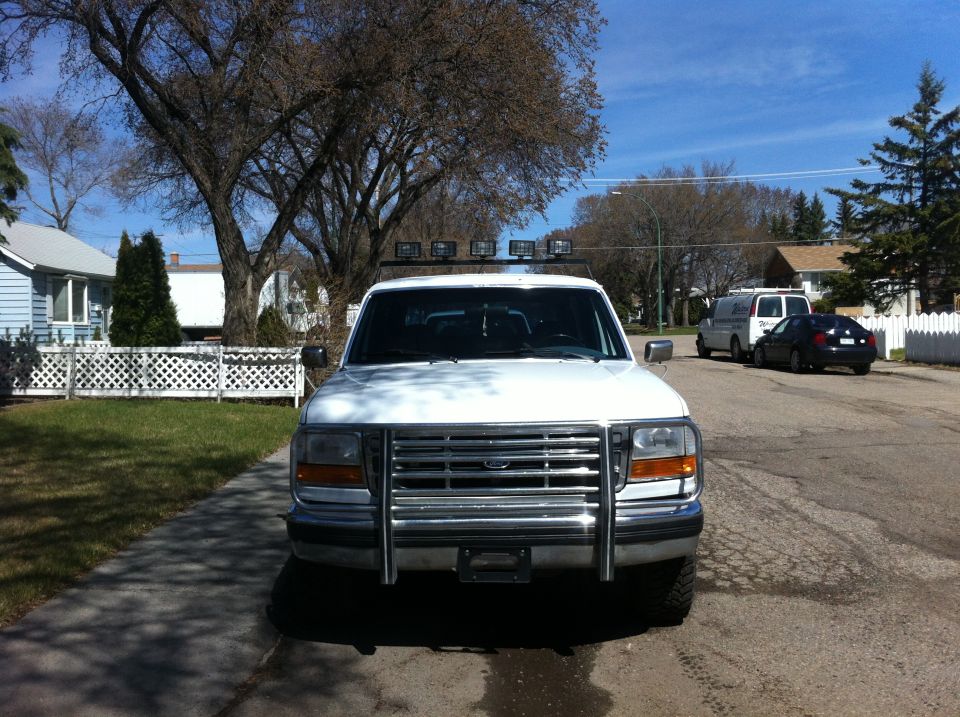 White 1994 Ford Bronco front view with chrome grille guard and roof lights