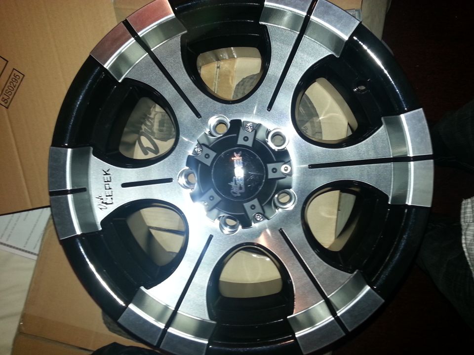 Close-up of a black and silver aftermarket wheel with 'LEPEK' written on it
