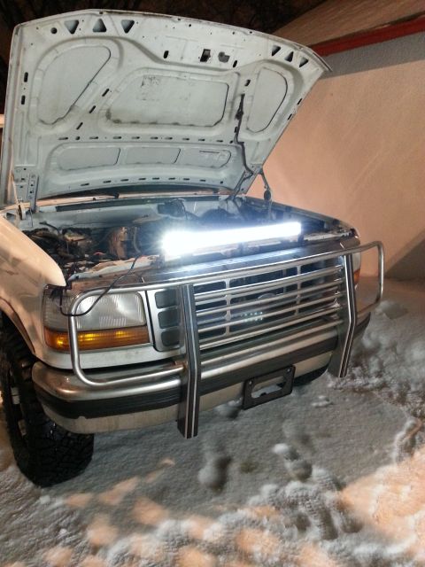 1994 Ford Bronco - Front view of a white Ford truck with its hood open, parked in the snow.