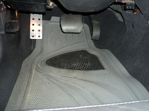 2004 Mercury Grand Marquis - The driver's side footwell shows the brake, accelerator, and clutch pedals, along with a heavy-duty floor mat.