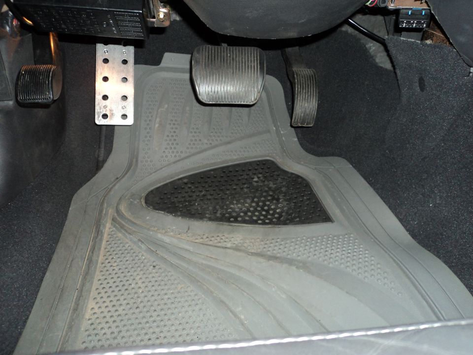 Interior driver's side footwell with pedals and floor mat