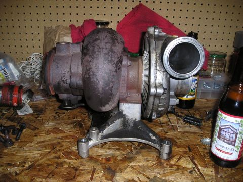1997 Ford F-250 - A turbocharger is shown on a wooden surface, with various workshop items in the background.