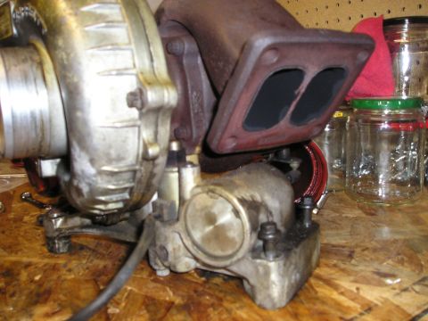 1997 Ford F-250 - Close-up of a turbocharger, likely removed from an engine, resting on a workbench.