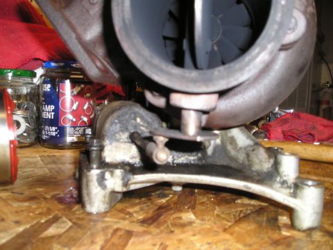 1997 Ford F-250 - A turbocharger assembly sits on a wooden surface, with jars of parts nearby.