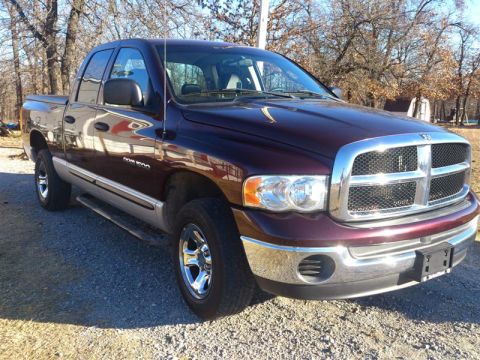 2004 Dodge 1500 - Maroon and silver Dodge Ram 1500 pickup truck from the front right side, parked outdoors on a sunny day.