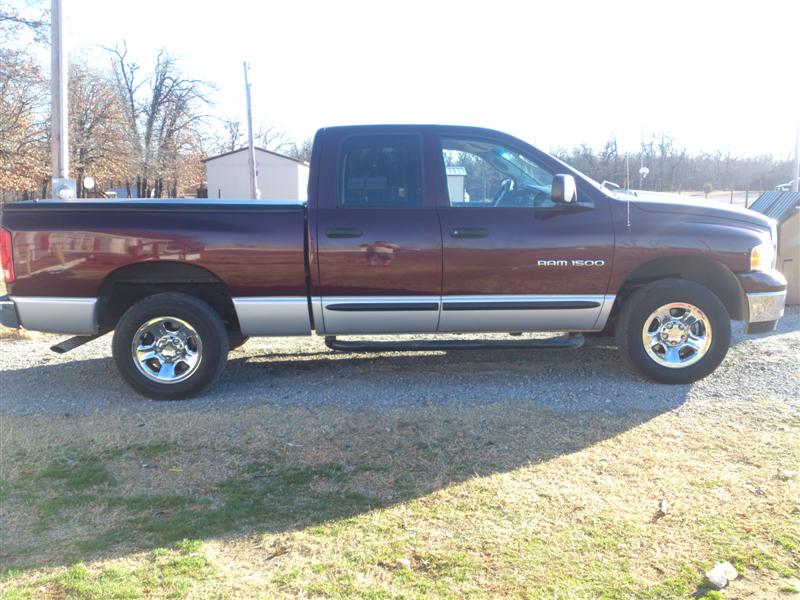 Side view of maroon 2004 Dodge Ram 1500 pickup truck with silver lower body trim