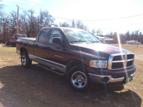 2004 Dodge 1500 - A maroon Dodge Ram 1500 pickup truck is parked outdoors on a sunny day, with another vehicle visible in the background.