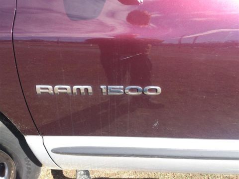 2004 Dodge 1500 - Close-up of the RAM 1500 badge on the side of a maroon pickup truck.
