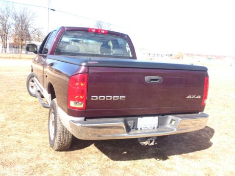 2004 Dodge 1500 - This Dodge pickup truck is seen from the rear, showing its 4x4 badging and a tonneau cover over the bed.