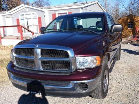2004 Dodge 1500 - Front view of a maroon Dodge Ram pickup truck parked in a gravel driveway.