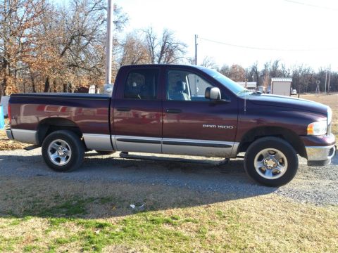 2004 Dodge 1500 - Side view of a maroon 2004 Dodge Ram 1500 pickup truck with a silver lower body trim.
