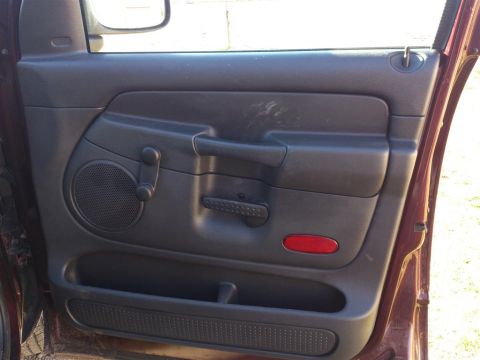 2004 Dodge 1500 - Interior door panel of a 2004 Dodge 1500 showing the speaker, window crank, and door handle.