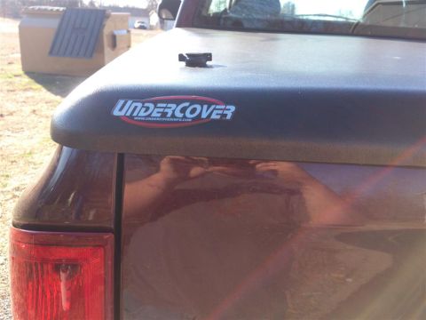 2004 Dodge 1500 - Close-up of a truck's rear with an Undercover tonneau cover and visible taillight.