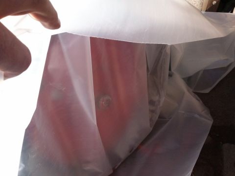 1994 Ford Bronco - A vehicle transmission part is partially obscured by white plastic sheeting.