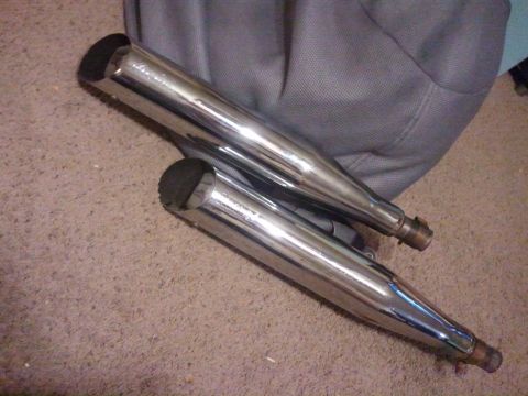 1995 Ford F-150 - A pair of chrome exhaust pipes are shown resting on a carpeted surface.