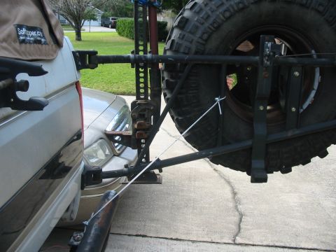 1992 Ford Bronco - This SUV features a spare tire and Hi-Lift jack mounted to its rear, with another vehicle partially visible in front.