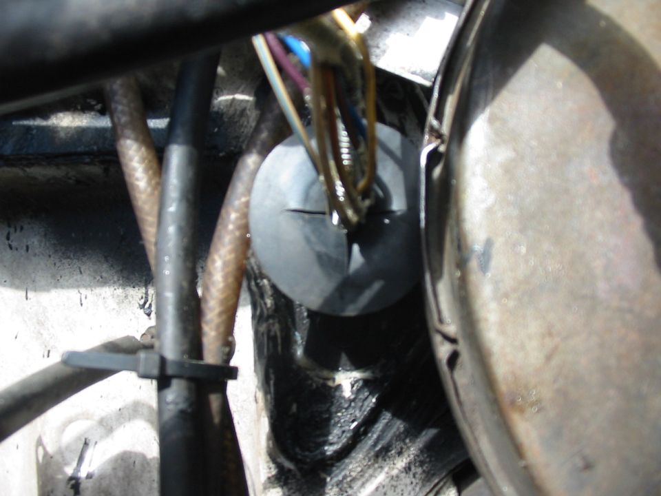 close-up of wiring harness going through firewall grommet in engine bay