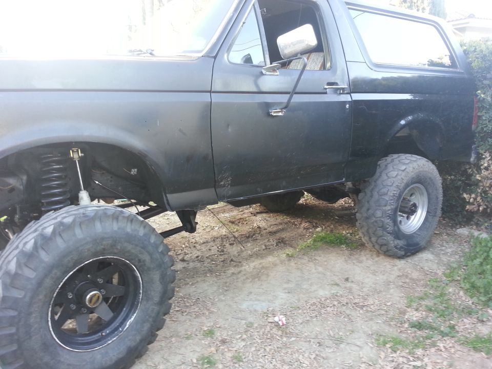 Black lifted SUV, side view, showing large tires and suspension