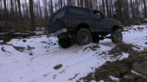 1995 Ford Bronco - This 1995 Ford Bronco navigates a challenging snowy path through a wooded area.