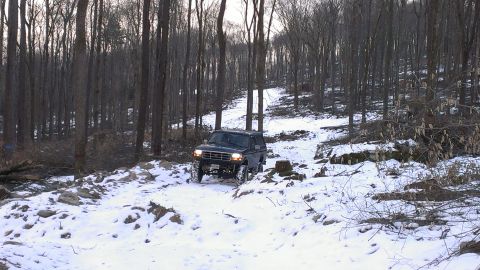 1995 Ford Bronco - A black 1995 Ford Bronco navigates a snowy, wooded path.