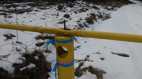 1995 Ford Bronco - A yellow barrier gate stands in a snowy landscape, adorned with blue and pink ribbons.
