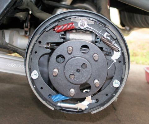 1976 Ford Ranchero - Close-up view of a vehicle's rear drum brake assembly, showing the brake shoes, springs, and wheel cylinder.