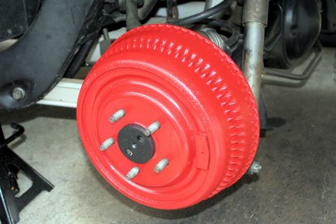 1976 Ford Ranchero - A close-up view of a red painted brake drum, part of a vehicle's braking system.