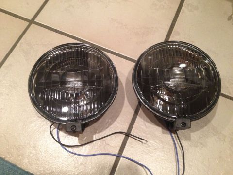 1996 Ford Bronco - A pair of aftermarket headlights are shown, disconnected and ready for installation.