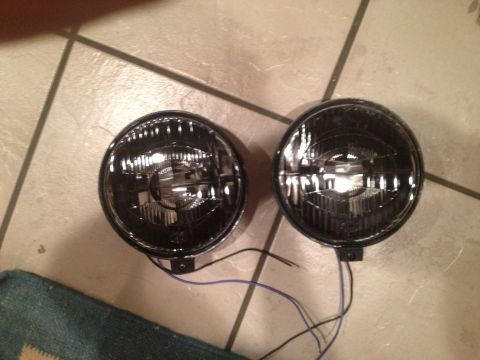 1996 Ford Bronco - Two round headlights with black bezels and visible internal reflectors are shown, each with wires extending from the base.