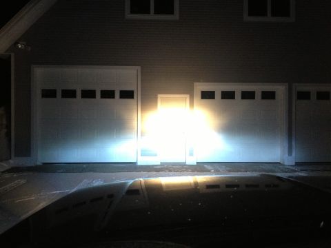 1996 Ford Bronco - Headlights illuminate a garage door from the perspective of a car's hood.
