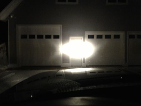 1996 Ford Bronco - Headlights illuminate a row of garage doors at night.