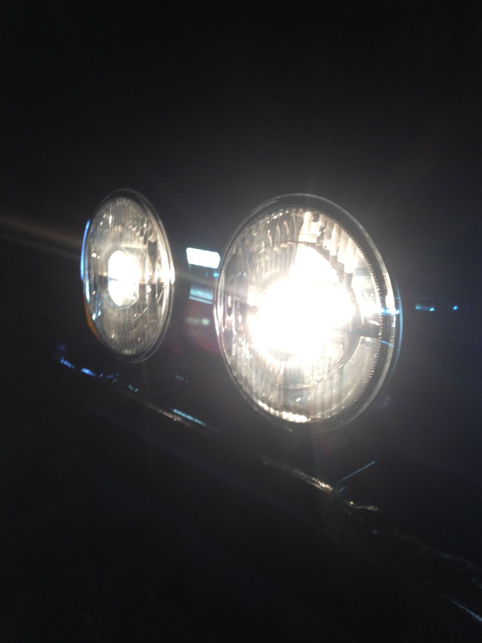 Two round headlights illuminated at night