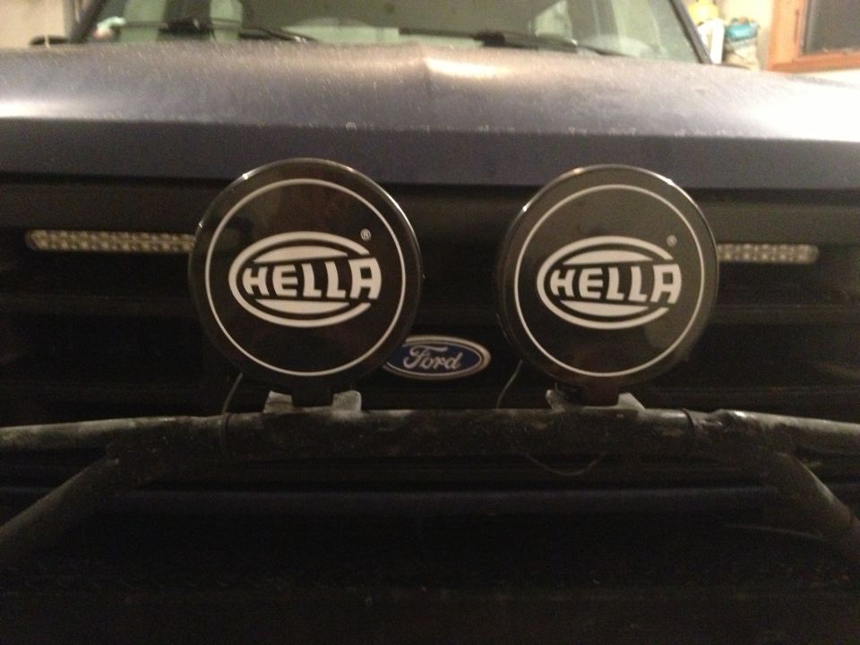 Front of a 1996 Ford Bronco with two Hella lights mounted on the grille guard