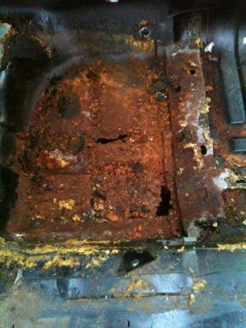 1975 Ford Ranchero - The floor pan of the vehicle is severely corroded and shows significant rust damage.