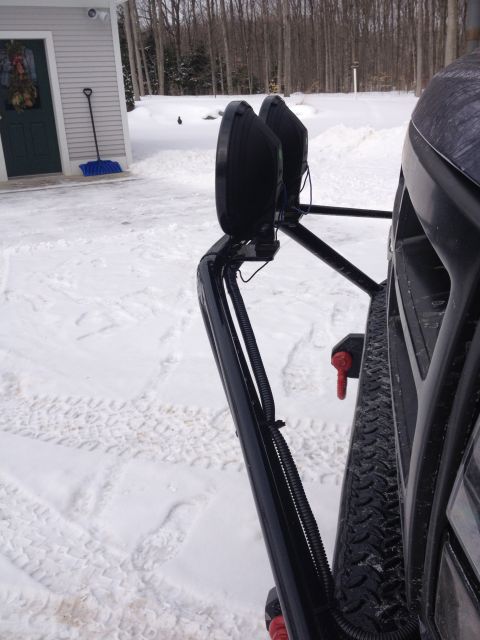 1996 Ford Bronco - Off-road lights are mounted on a vehicle's bumper, with a snowy driveway and trees in the background.