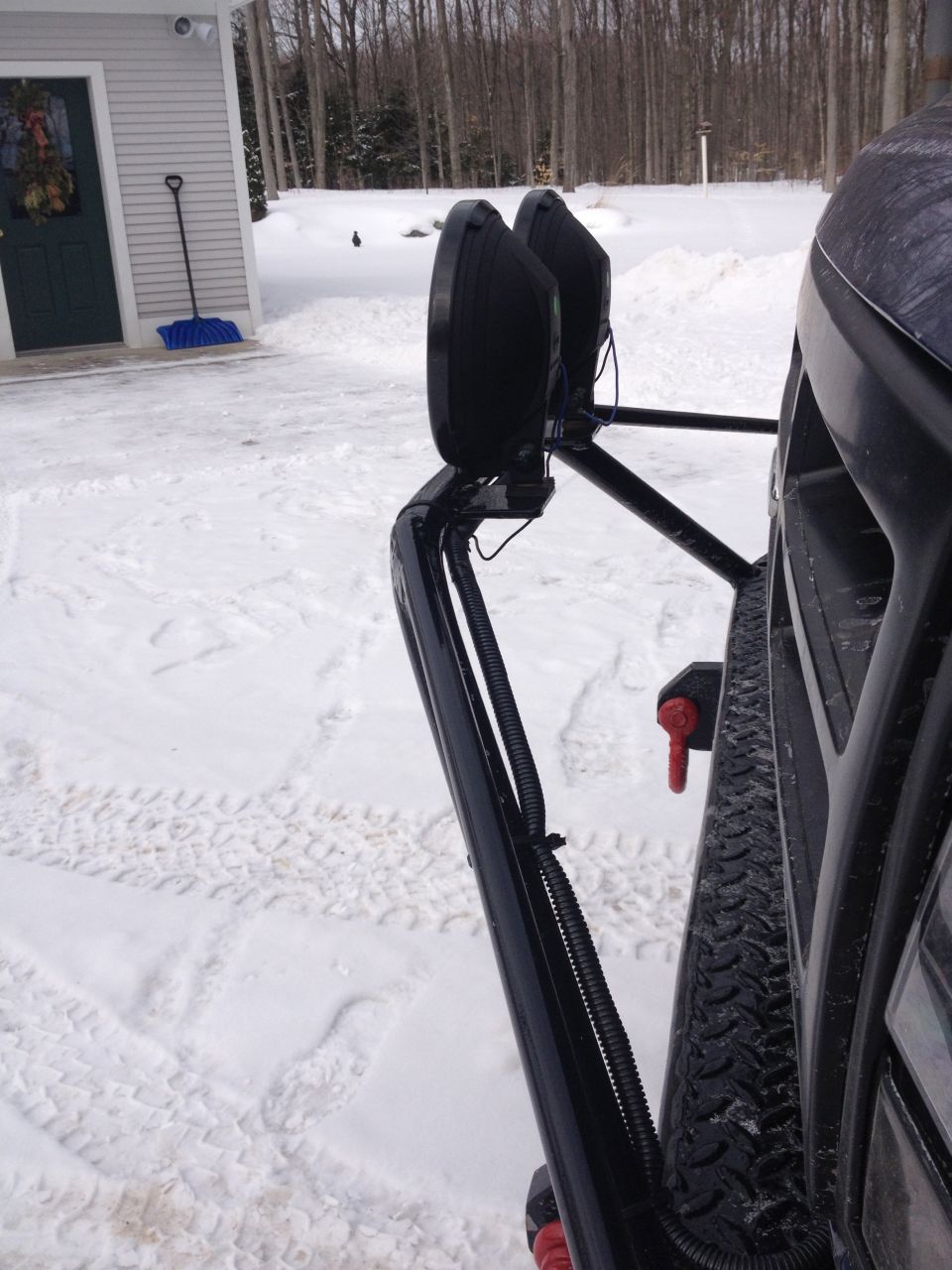 close-up of off-road lights mounted on a vehicle's bumper in the snow