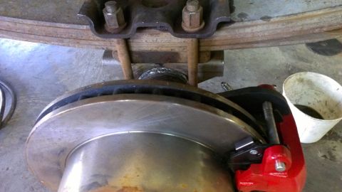 1995 Ford Bronco - This image shows a close-up of a vehicle's brake rotor, caliper, and leaf spring suspension system.