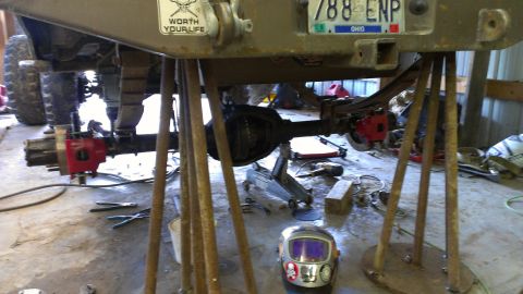 1995 Ford Bronco - Rear axle and suspension of a 1995 Ford Bronco, supported by jack stands, with a "Worth Your Life" sticker visible on the frame.